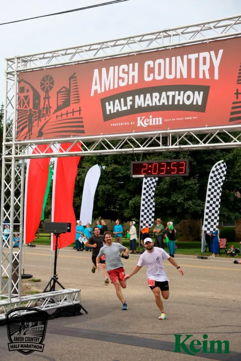 Logan Miller crossing the finish line at the 2026 Amish Country Half Marathon